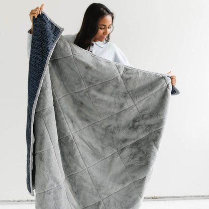 Woman holding Saranoni Outdoor Blanket against a white background
