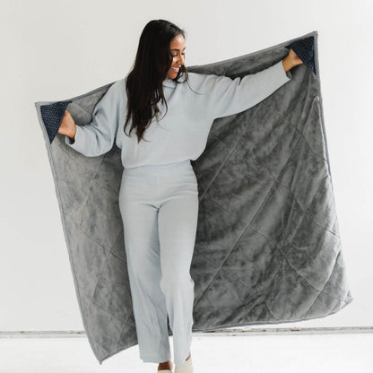 Woman holding Saranoni Outdoor Blanket against a white background
