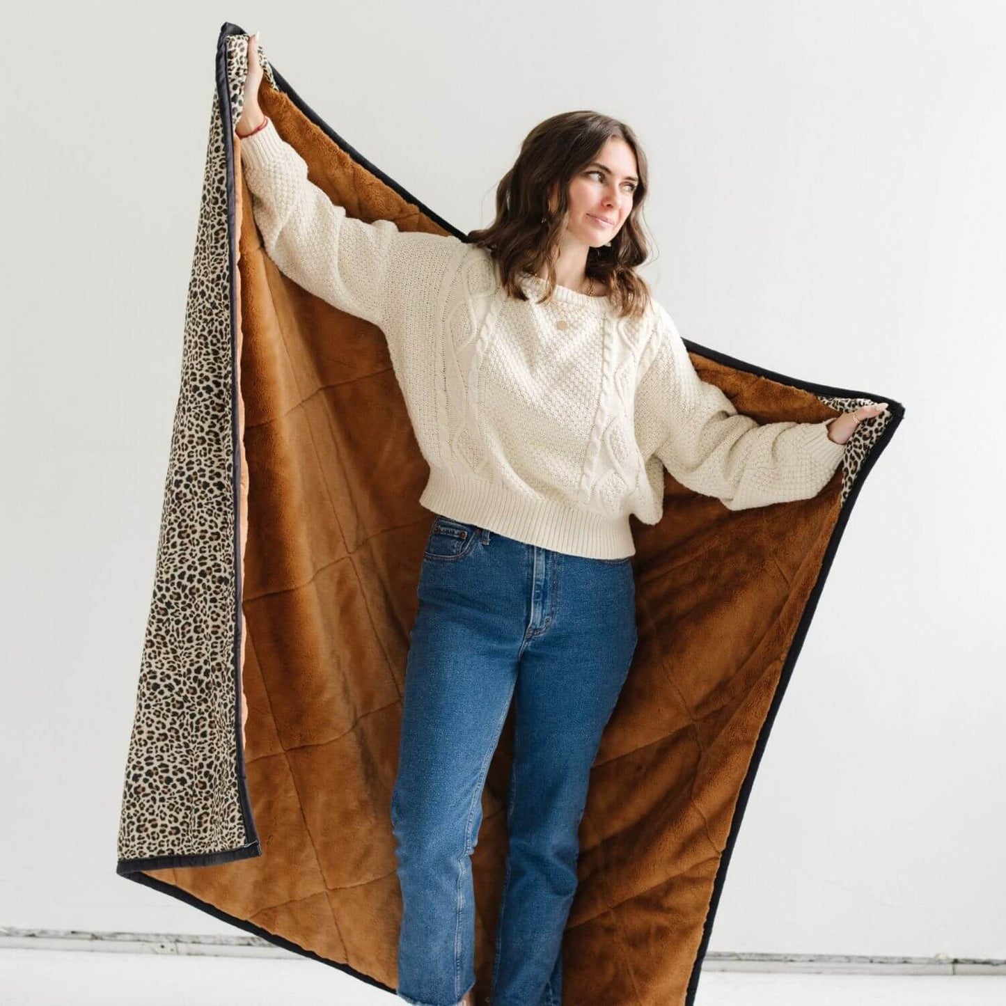 Woman holding Saranoni Outdoor Blanket against a white background
