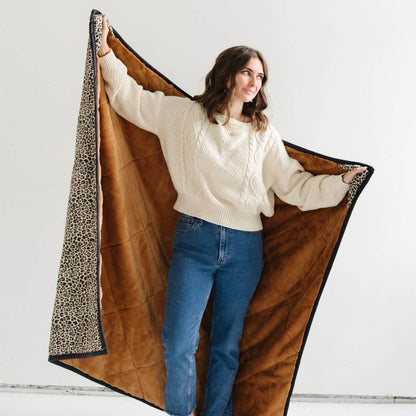 Woman holding Saranoni Outdoor Blanket against a white background