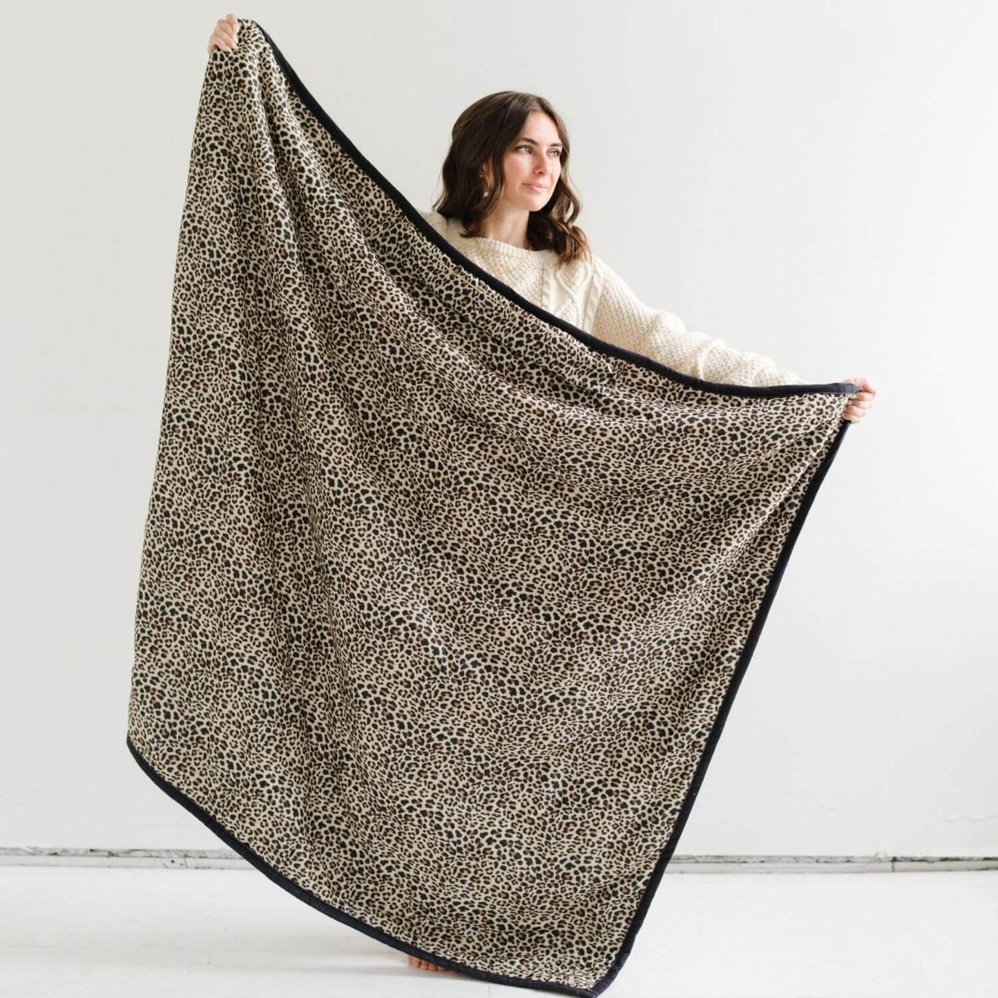 Person holding Saranoni Outdoor Blanket with a white background