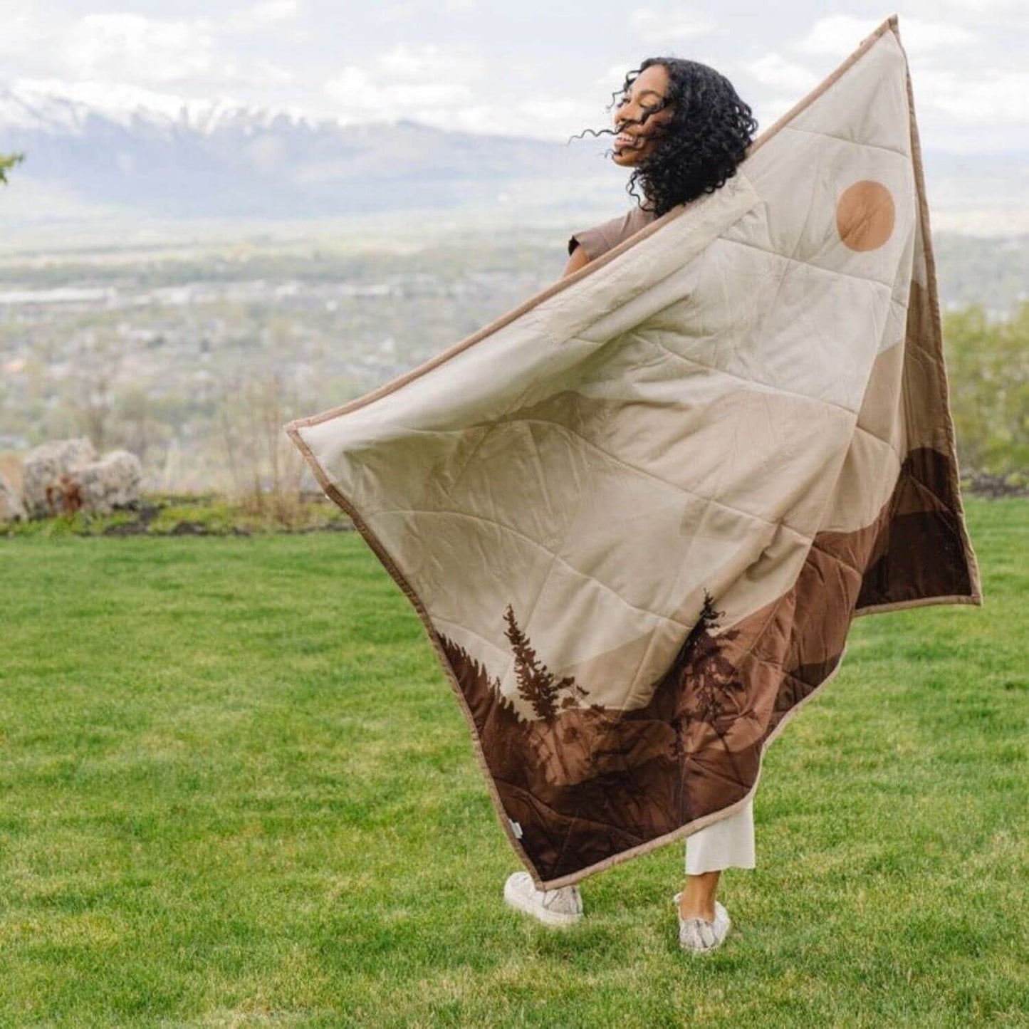 Person holding Saranoni Outdoor Blanket in an outdoor setting