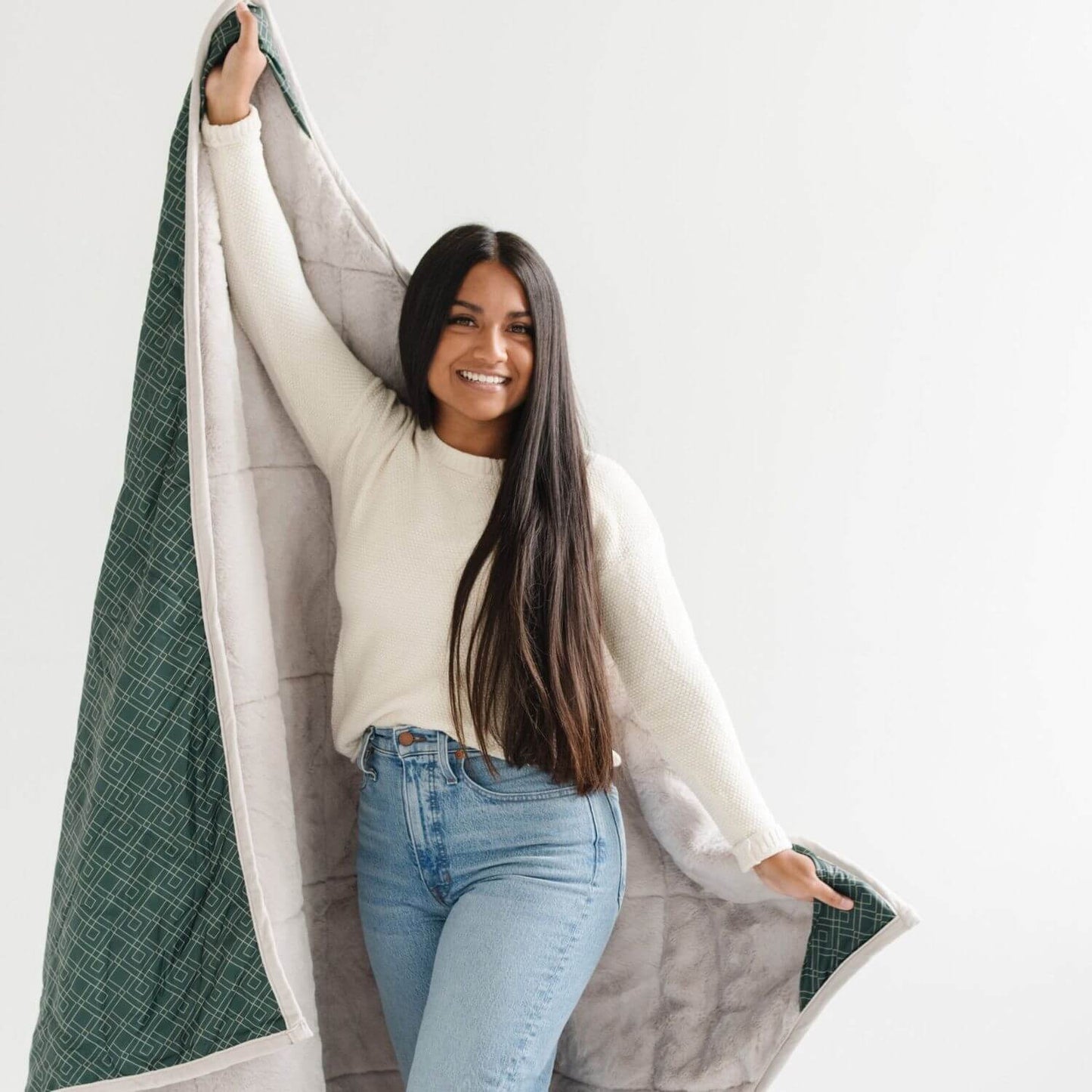 Woman holding Saranoni Outdoor Blanket against a white background
