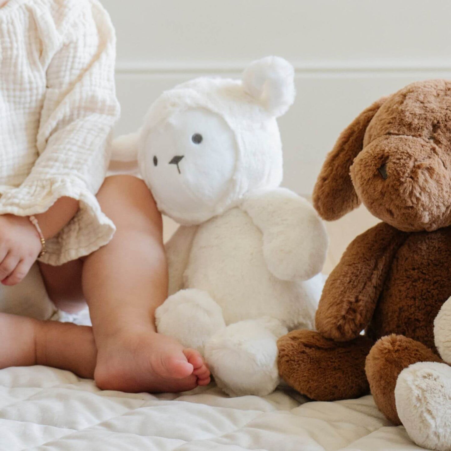 Child sitting on a bed with Saranoni Stuffed Animals