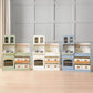 Set of Tiny Land® Serenity Play Kitchen on a wooden floor with a gray paneled wall background.