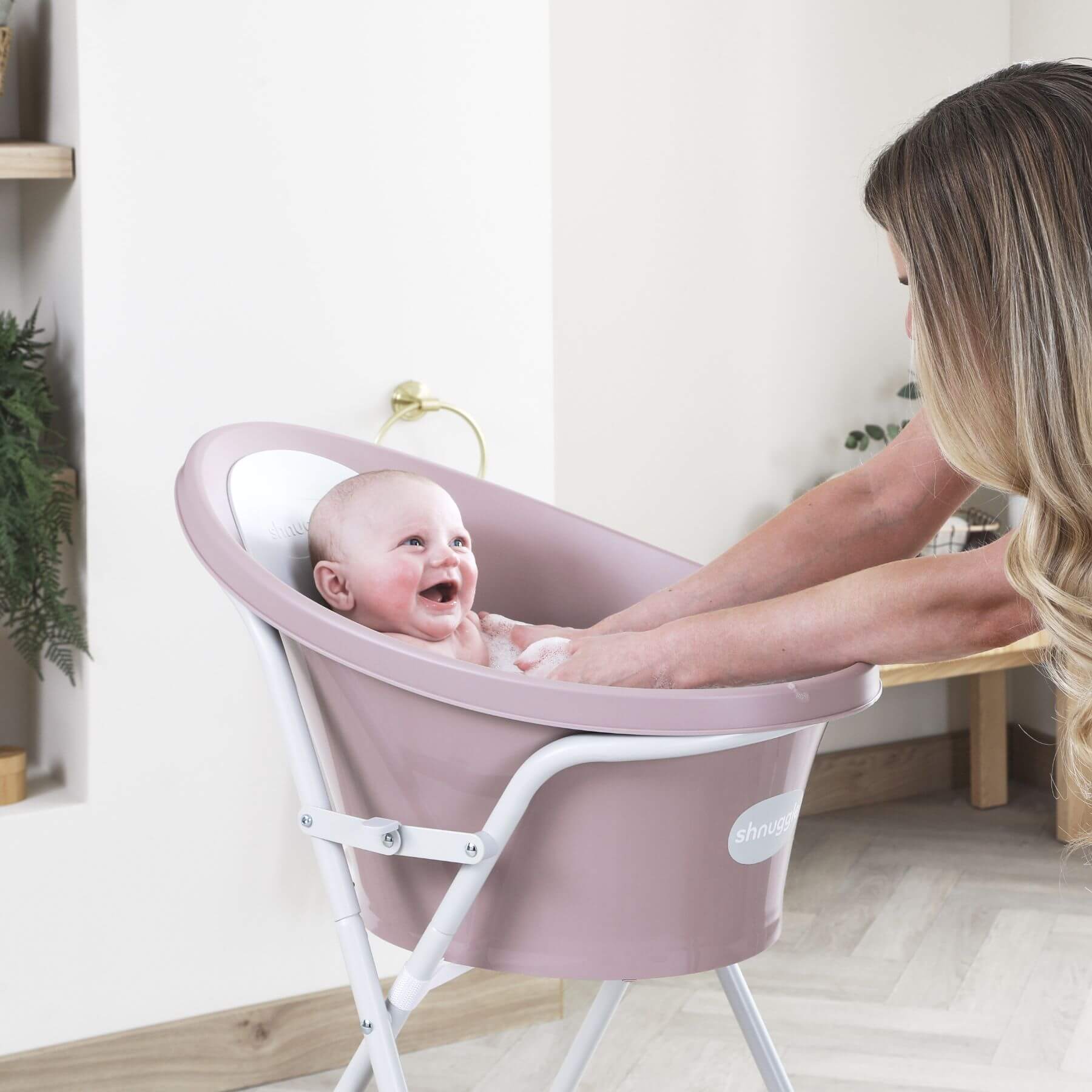 Baby in Shnuggle Bath with a woman in a home setting