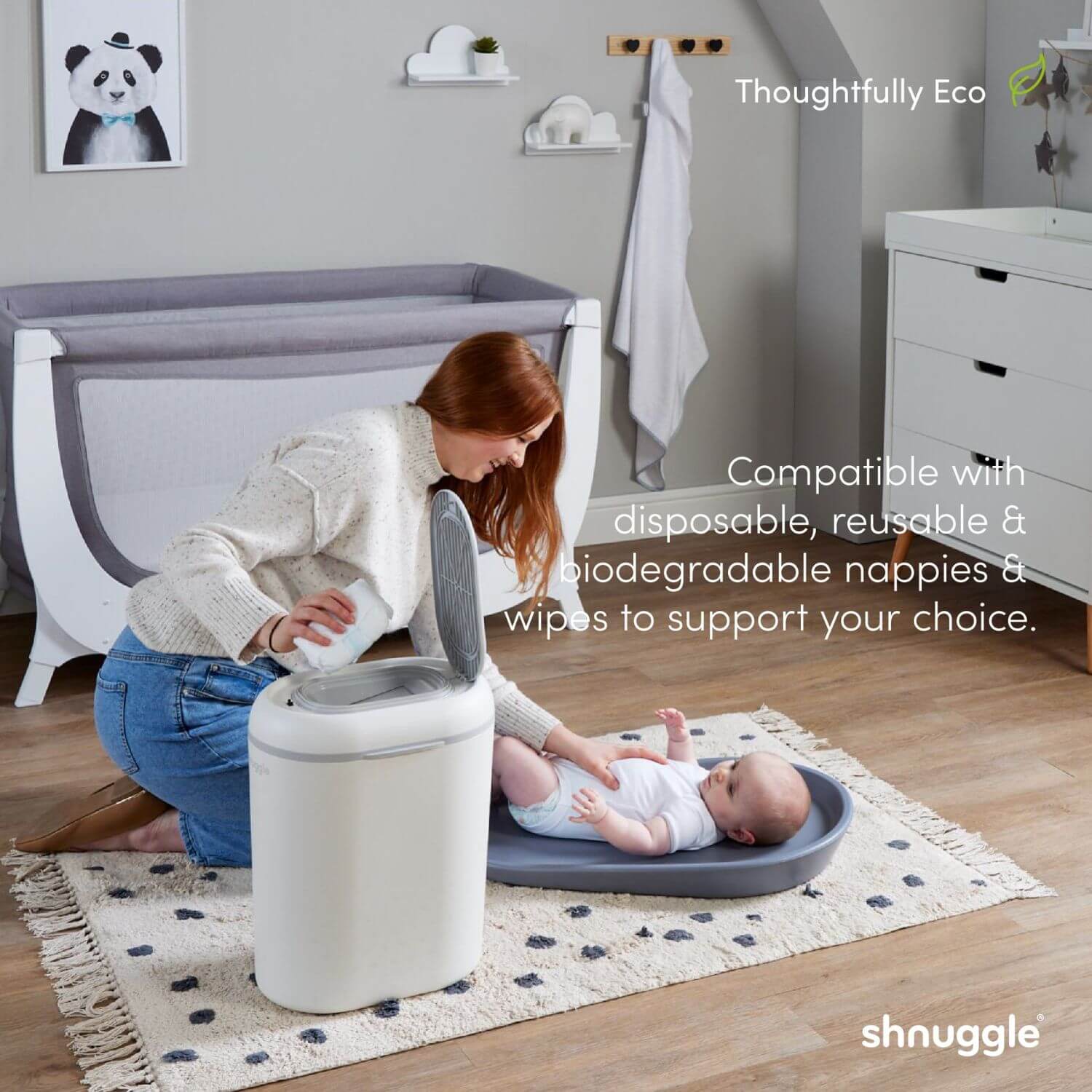 Woman with a baby using a shnuggle nappy bin in a nursery setting.
