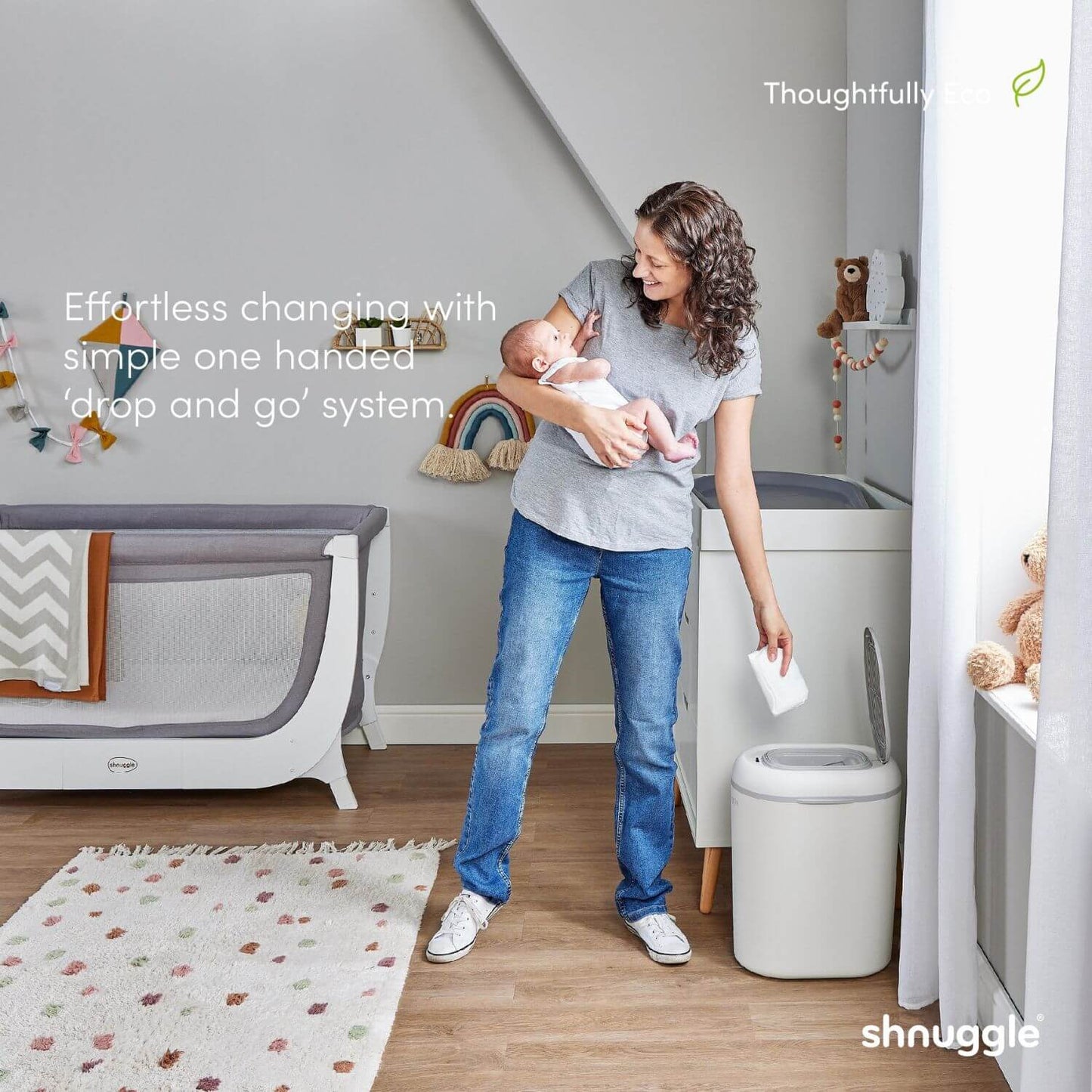Woman holding a baby in a nursery with a shnuggle product.