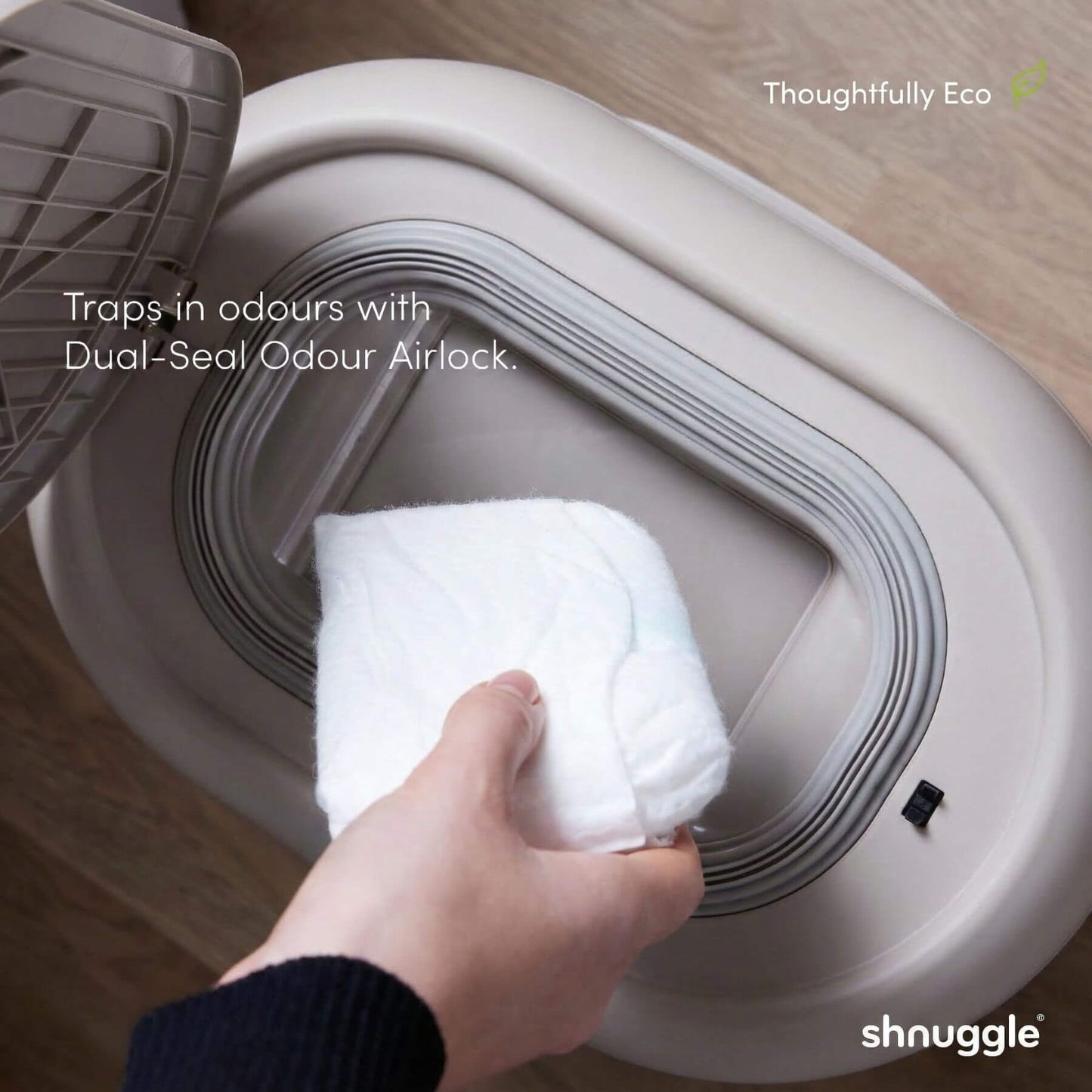 Person placing a white towel into Shnuggle Eco-Touch Nappy Bin Diaper Pail - Taupe