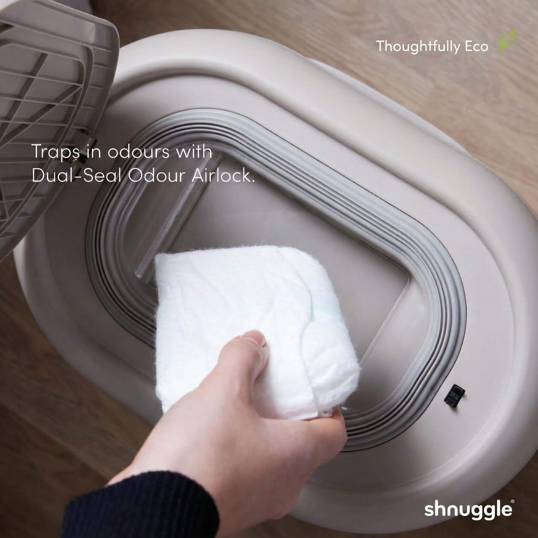 Person placing a white towel into Shnuggle Eco-Touch Nappy Bin Diaper Pail - Taupe
