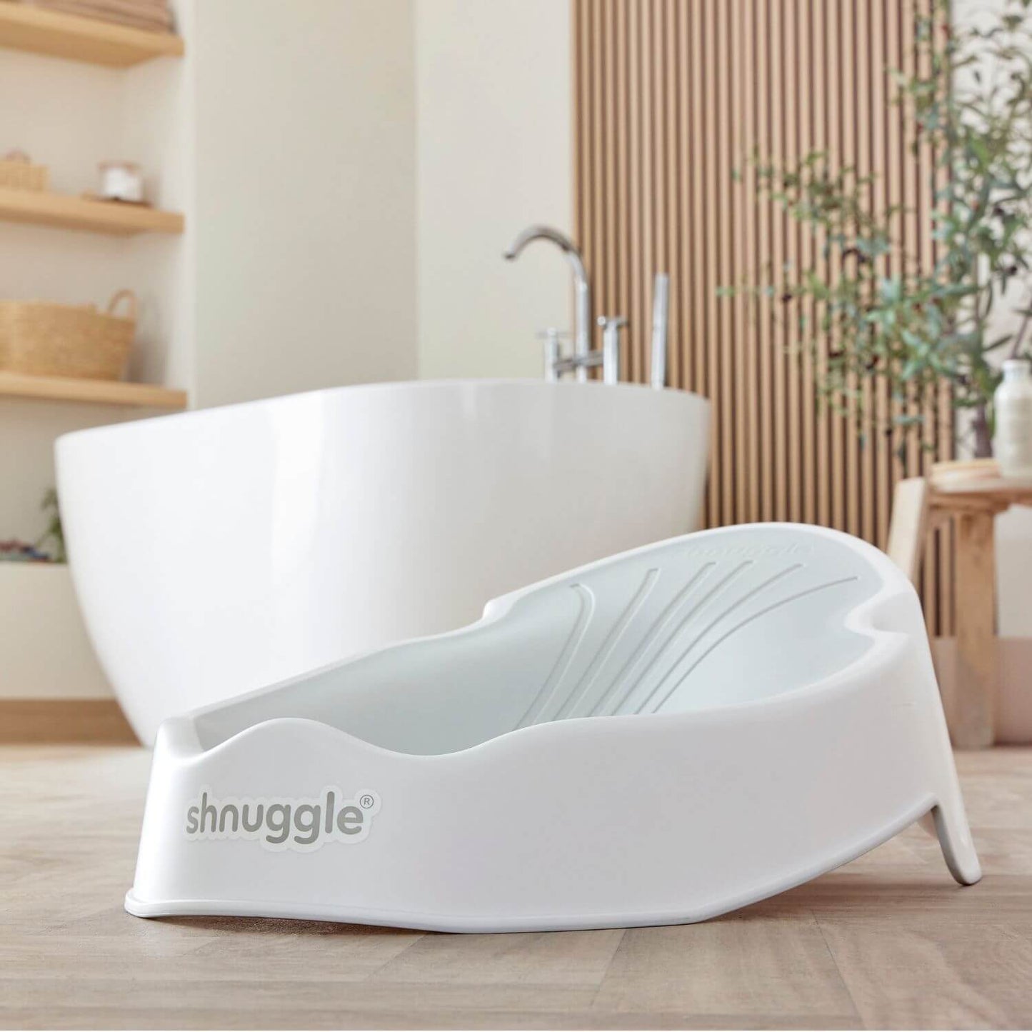 Shnuggle Newborn Baby Bath Support - White in a bathroom