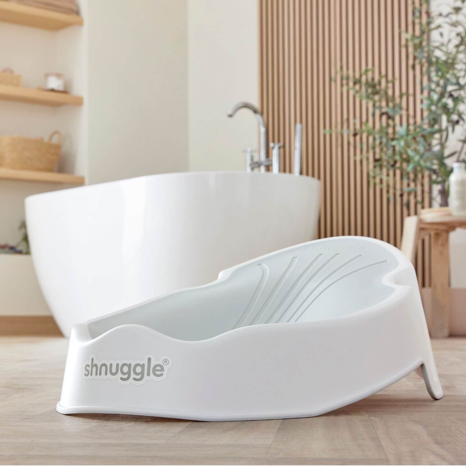 Shnuggle Newborn Baby Bath Support - White in a bathroom