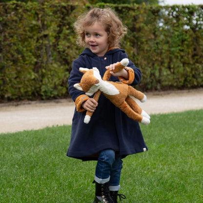 Child holding sigikid Organic Plush Fox outdoors on grass