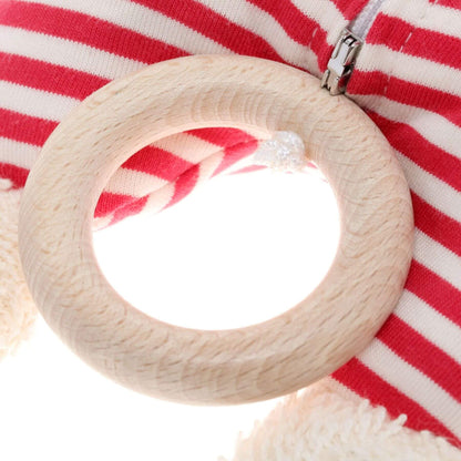 Wooden teething ring on a red and white striped fabric background