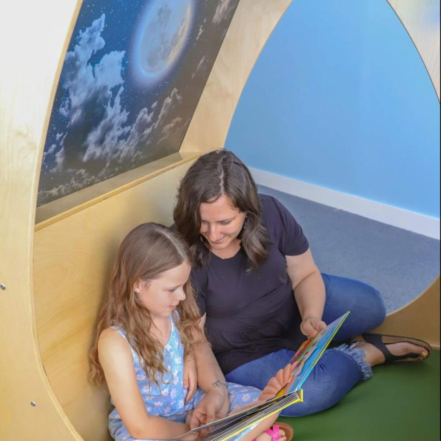 Mom and girl reading in Whitney Brothers Sky View Sanctuary