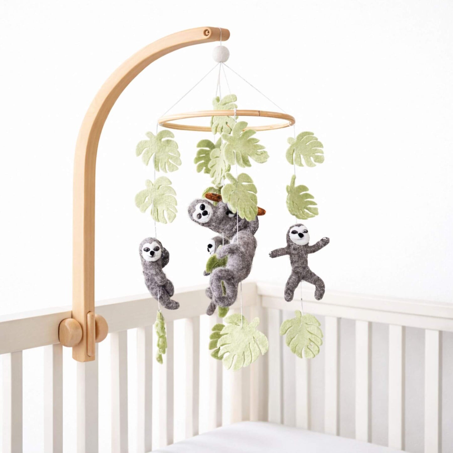 Ganapati Crafts Co. Sloth Baby Mobile hanging from a wooden arch over a crib.