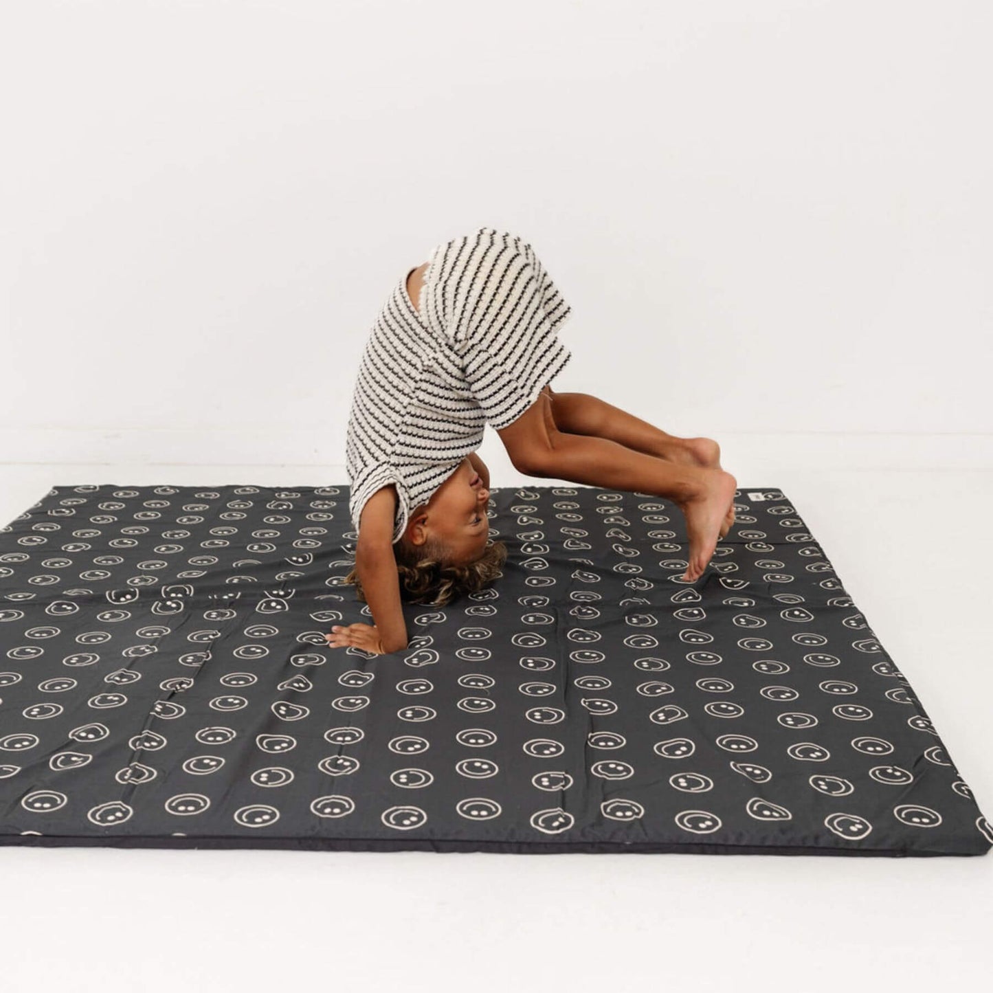 Person doing a handstand on Toki Kids Smiles Organic Cotton Mat