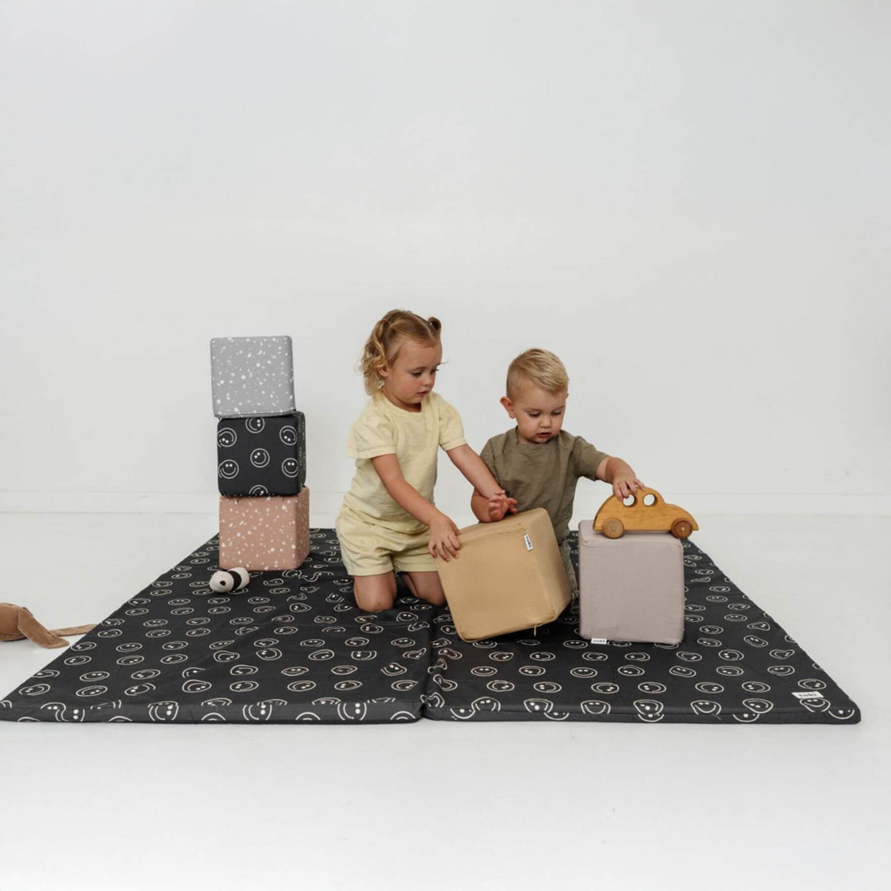 Two children playing with toys on Toki Kids Smiles Organic Cotton Mat