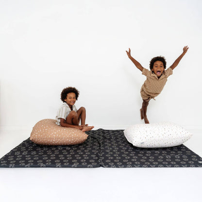 Two children playing on Toki Kids Smiles Organic Cotton Mat with pillows on a white background
