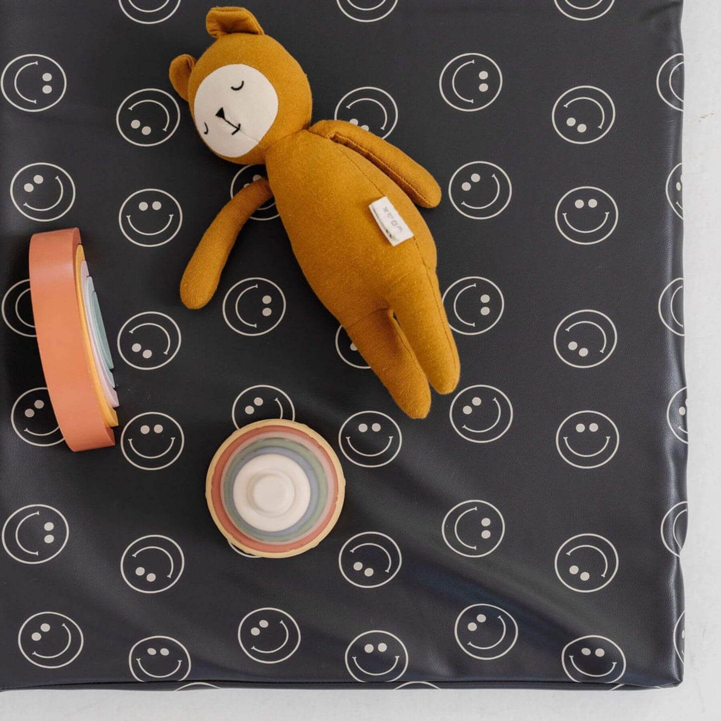 Yellow teddy bear and two small containers on Toki Kids Smiles Vegan Leather Mat