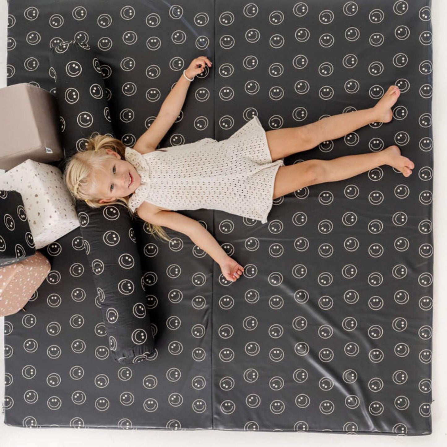 Child lying on Toki Kids Smiles Vegan Leather Mat