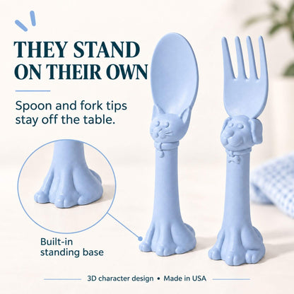 Spoon la la Toddler Utensils — 2-Pack - Blue, shown on a light neutral background with promotional text explaining that the utensils stand on their own.