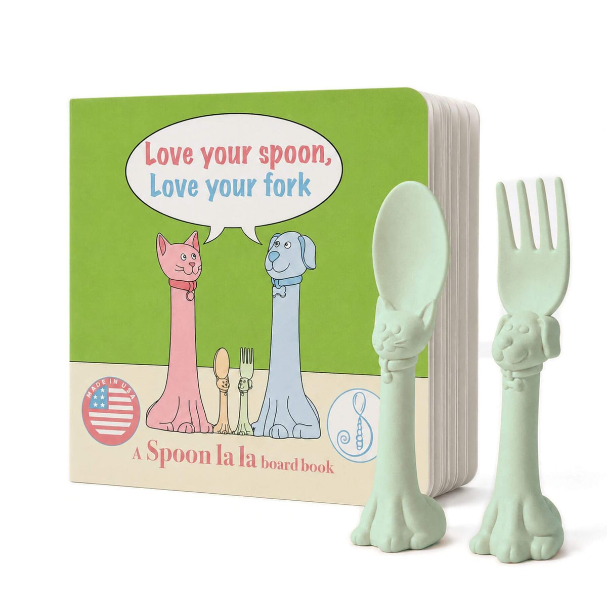 A Spoon la la board book set featuring a green board book with cartoon cat and dog figures and a matching mint green spoon and fork shaped like animal heads, shown on a white background.