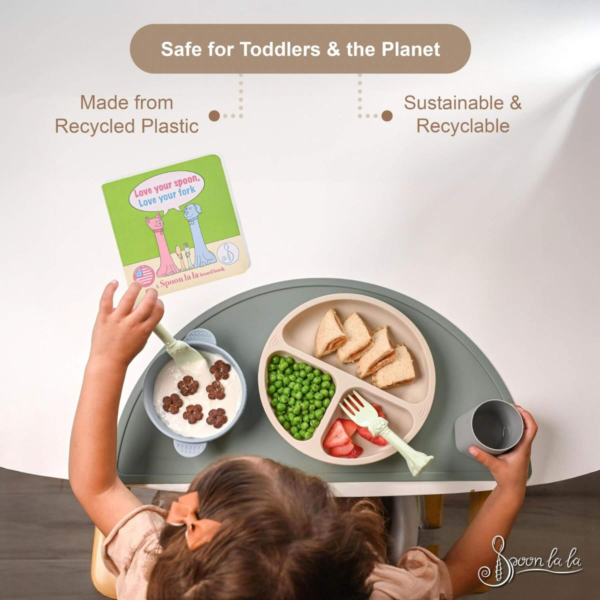 Child using a sustainable and recyclable children's table and chair set with a meal on a white background.