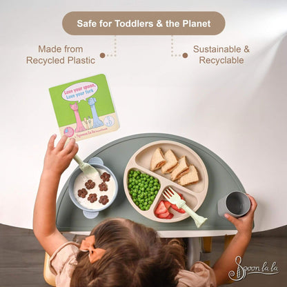 Child using a sustainable and recyclable children's table and chair set with a meal on a white background.