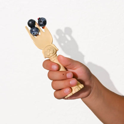 Hand holding a wooden fork with blueberries on a white background