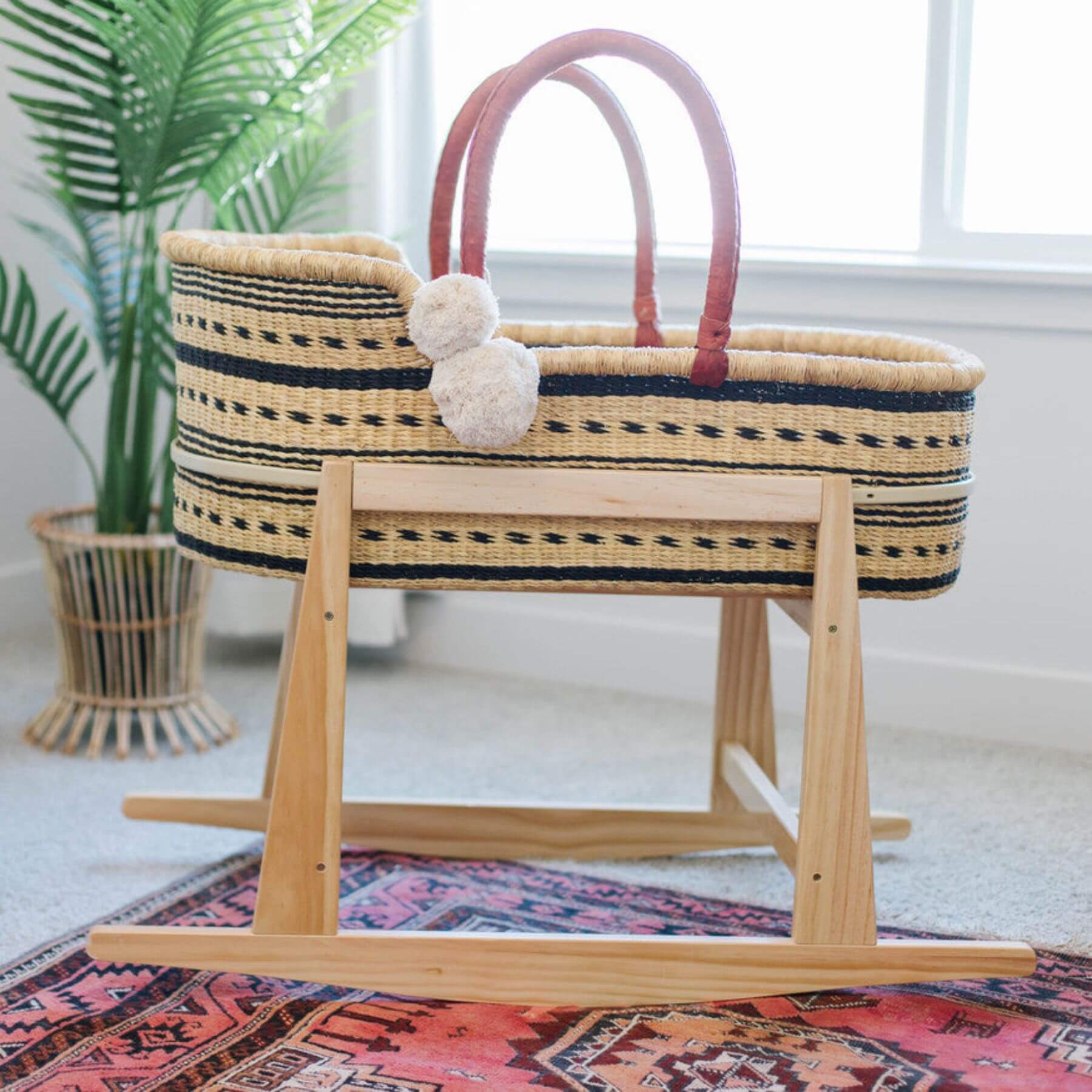 Spring Sparrow African Moses Basket with wooden stand on a colorful rug