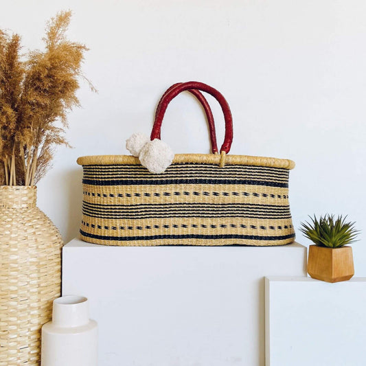 Spring Sparrow No Hood African Moses Basket on a white surface, surrounded by decorative items.