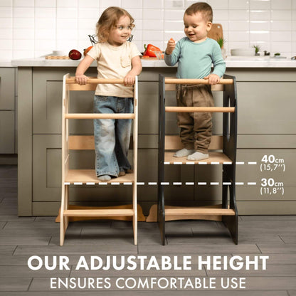 Two kids standing on Goodevas Stable Montessori Learning Tower next to kitchen counter