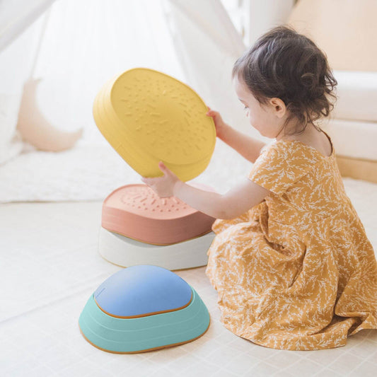 Child playing with Tiny Land® Stepping Stones - Beach Vacation on a light-colored floor.