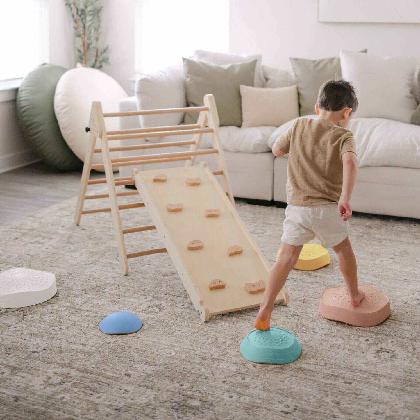 Child playing with Tiny Land® Stepping Stones - Beach Vacation in a living room.