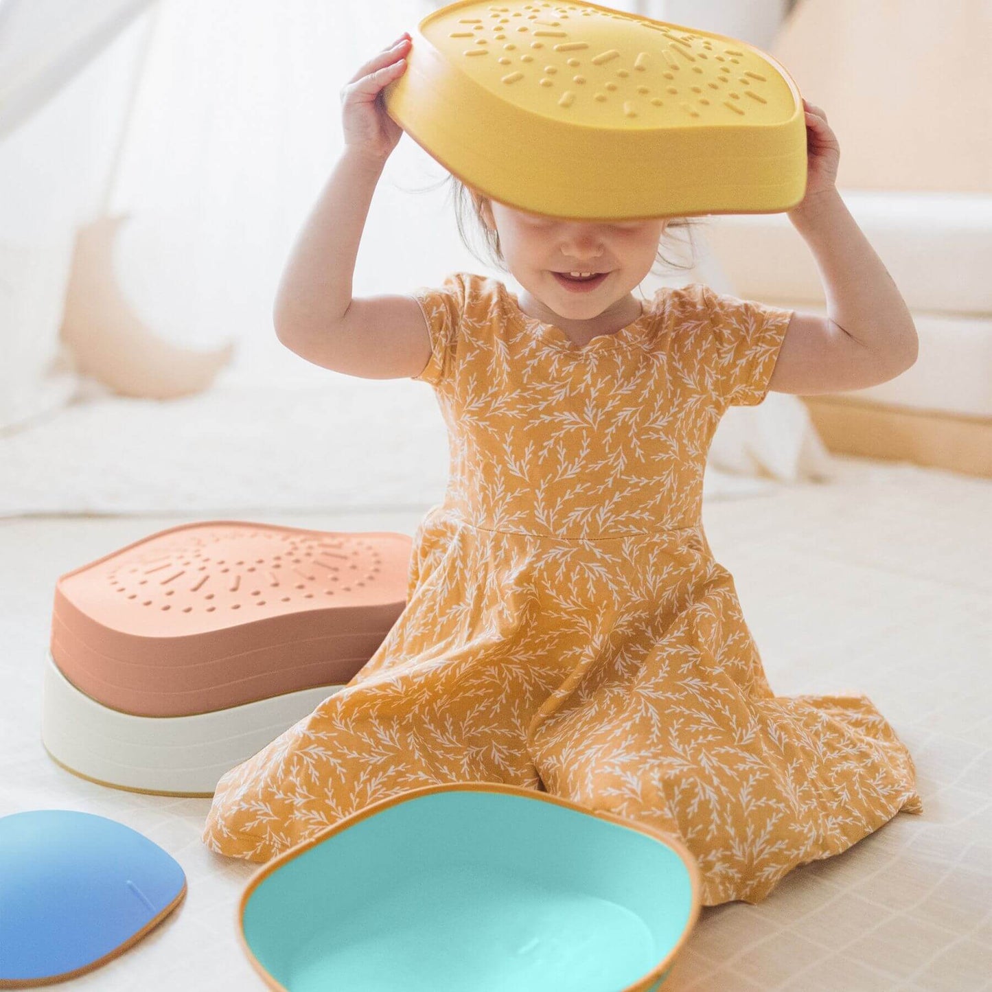 Child playing with Tiny Land® Stepping Stones - Beach Vacation on a light-colored floor.