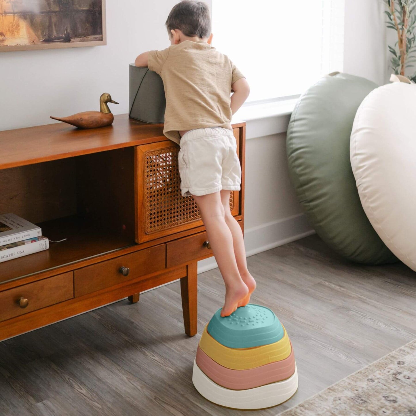 Child standing on Tiny Land® Stepping Stones - Beach Vacation in a room with wooden furniture and décor.