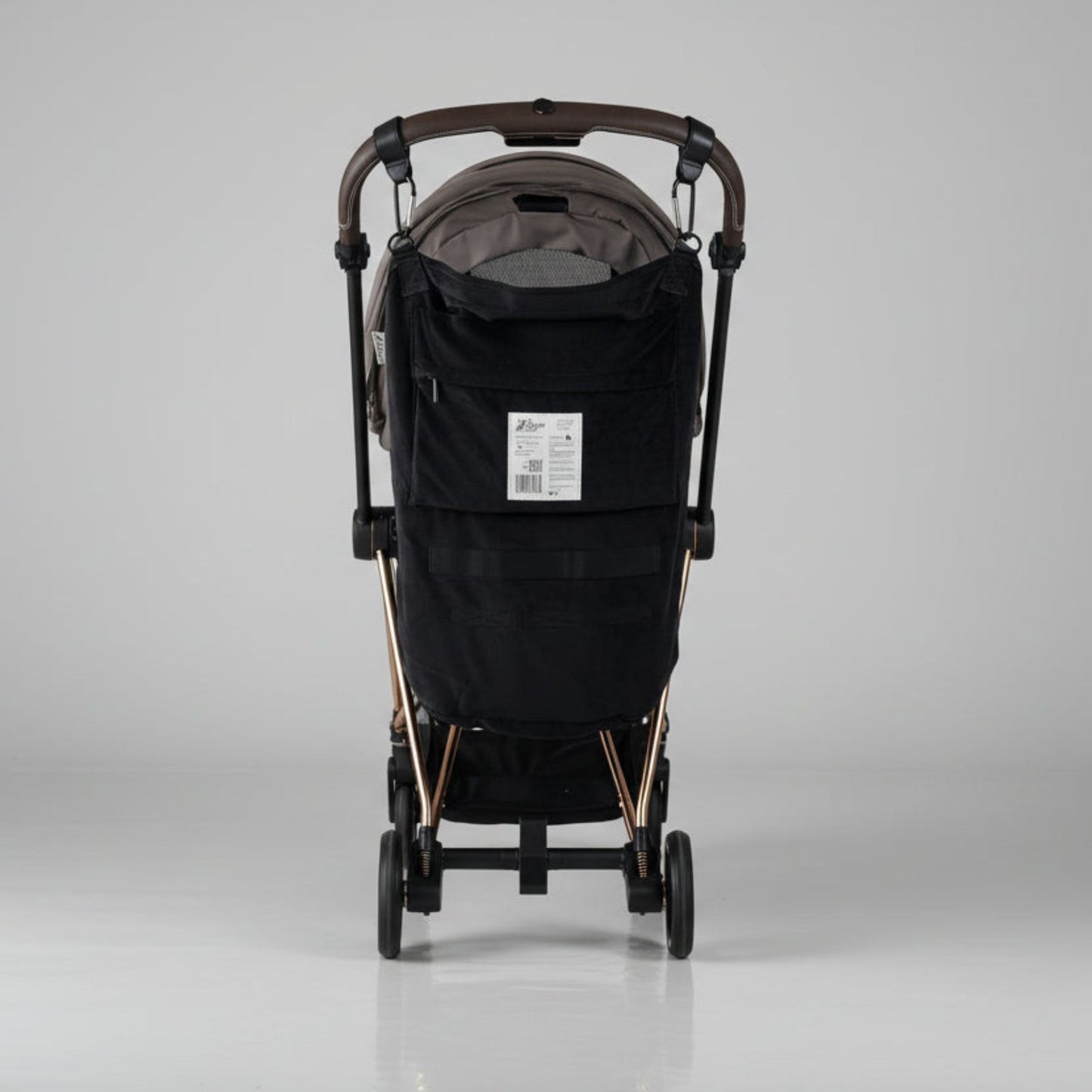 Black stroller with Stroller Sling™ – Black Fox Edition attached on a gray background