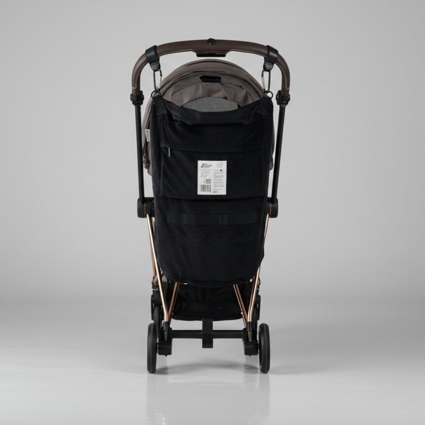 Black stroller with Stroller Sling™ – Black Fox Edition attached on a gray background