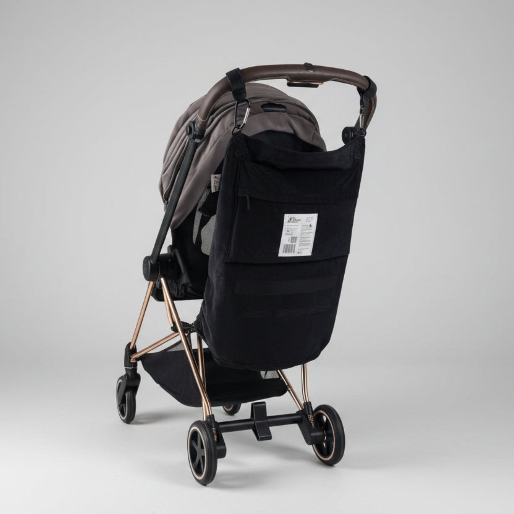 Black stroller with rose gold accents with Stroller Sling™ – Black Fox Edition attached
