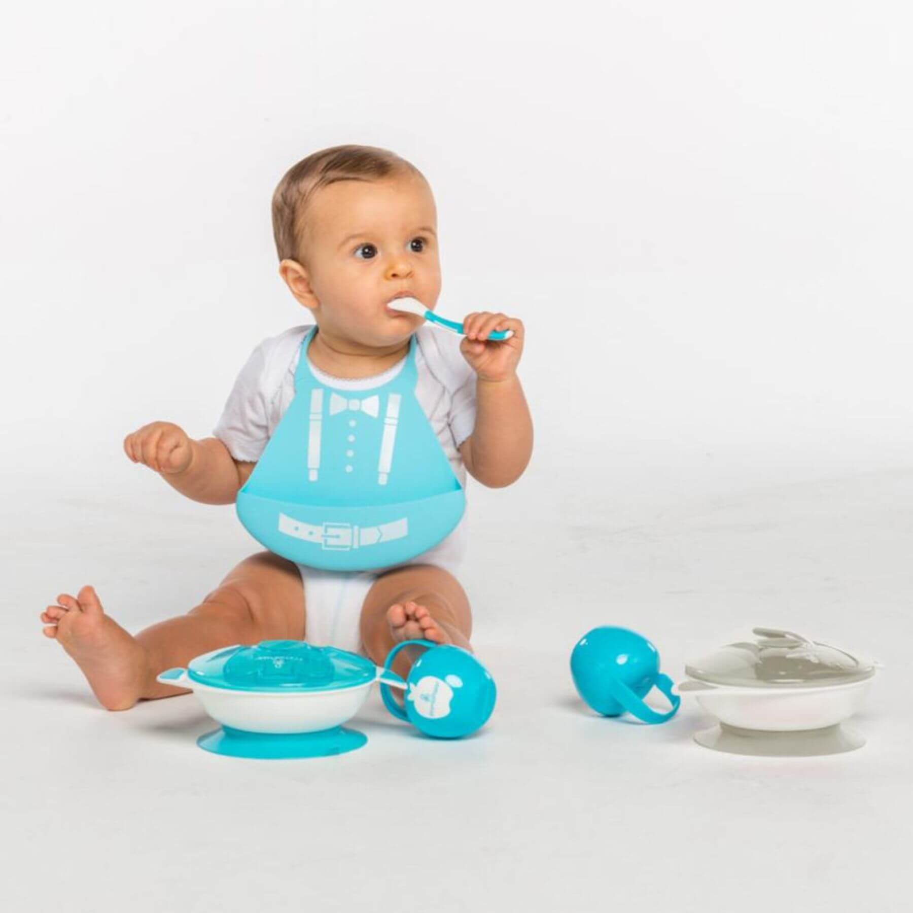 Baby sitting with a turquoise bib and Primo Passi Suction Bowl Feeding Set