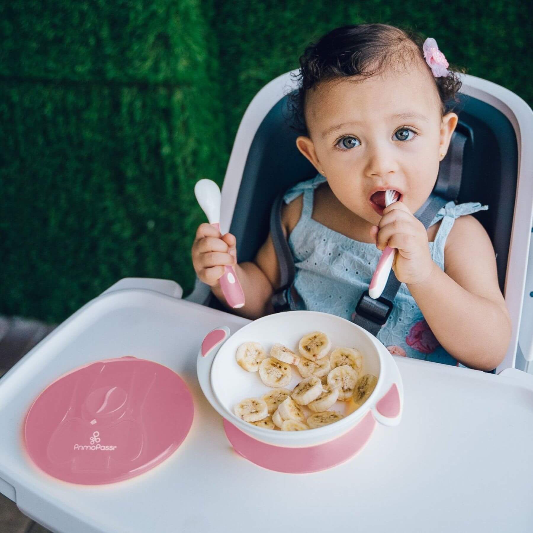 Baby in a high chair with a bowl of food and Primo Passi Suction Bowl Feeding Set