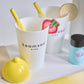 White cup with yellow straw, lemon-shaped container, and 'teamson kids' packaging on a white surface.