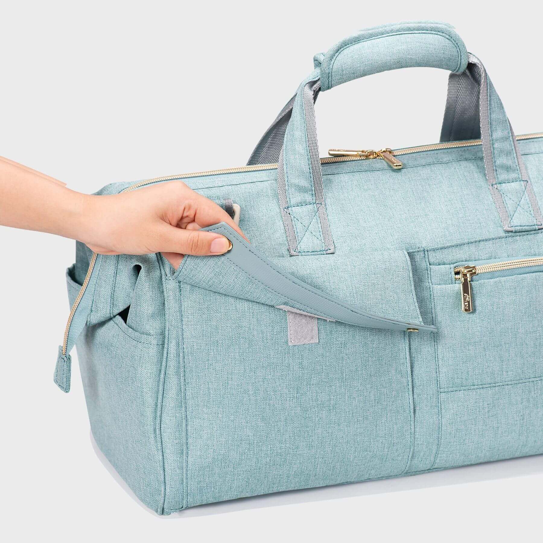 Sunveno 3 in 1 Diaper Travel Tote Bag - Green with a hand holding it on a light gray background