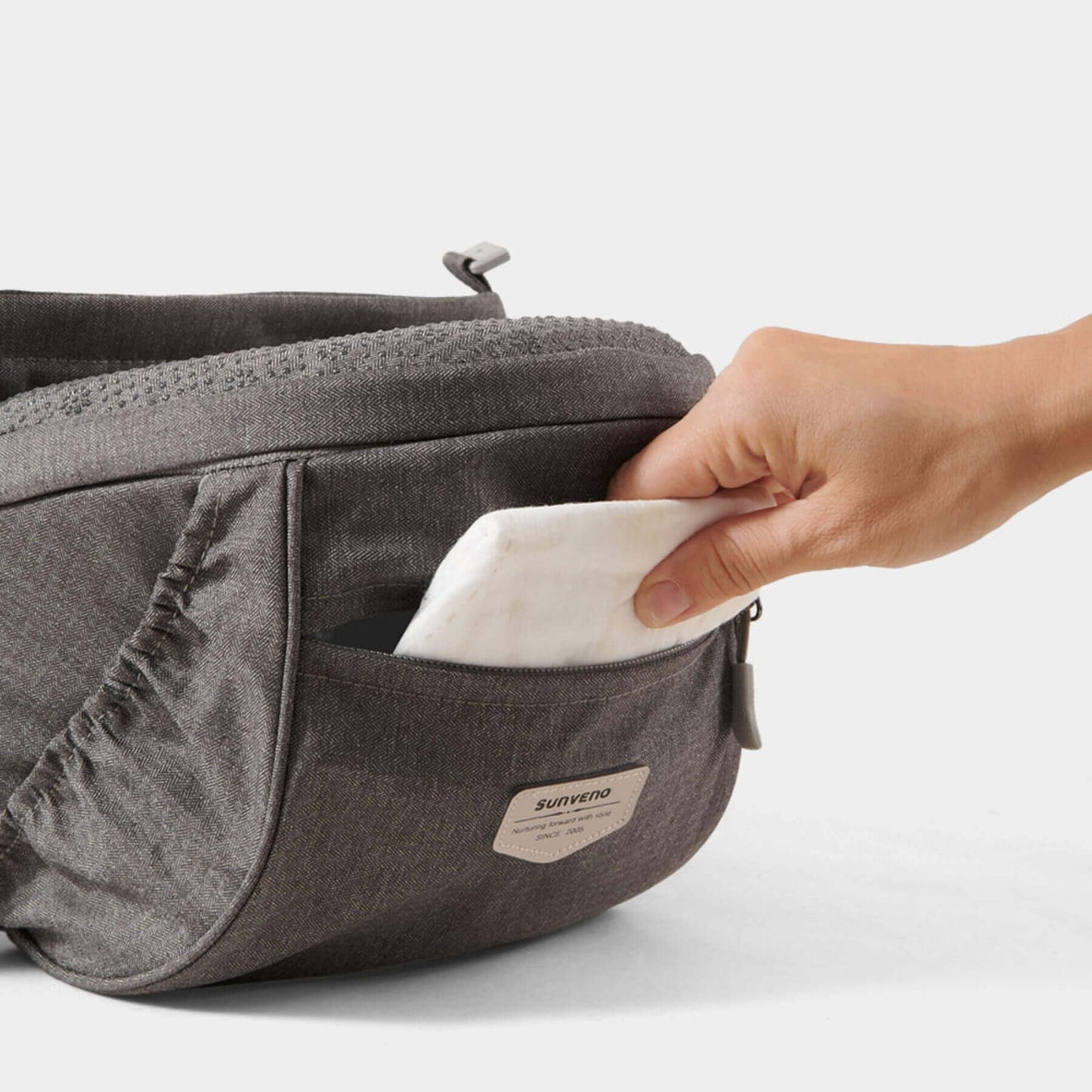 Person taking a white napkin from Sunveno Two Shoulder Straps Baby Hipseat
