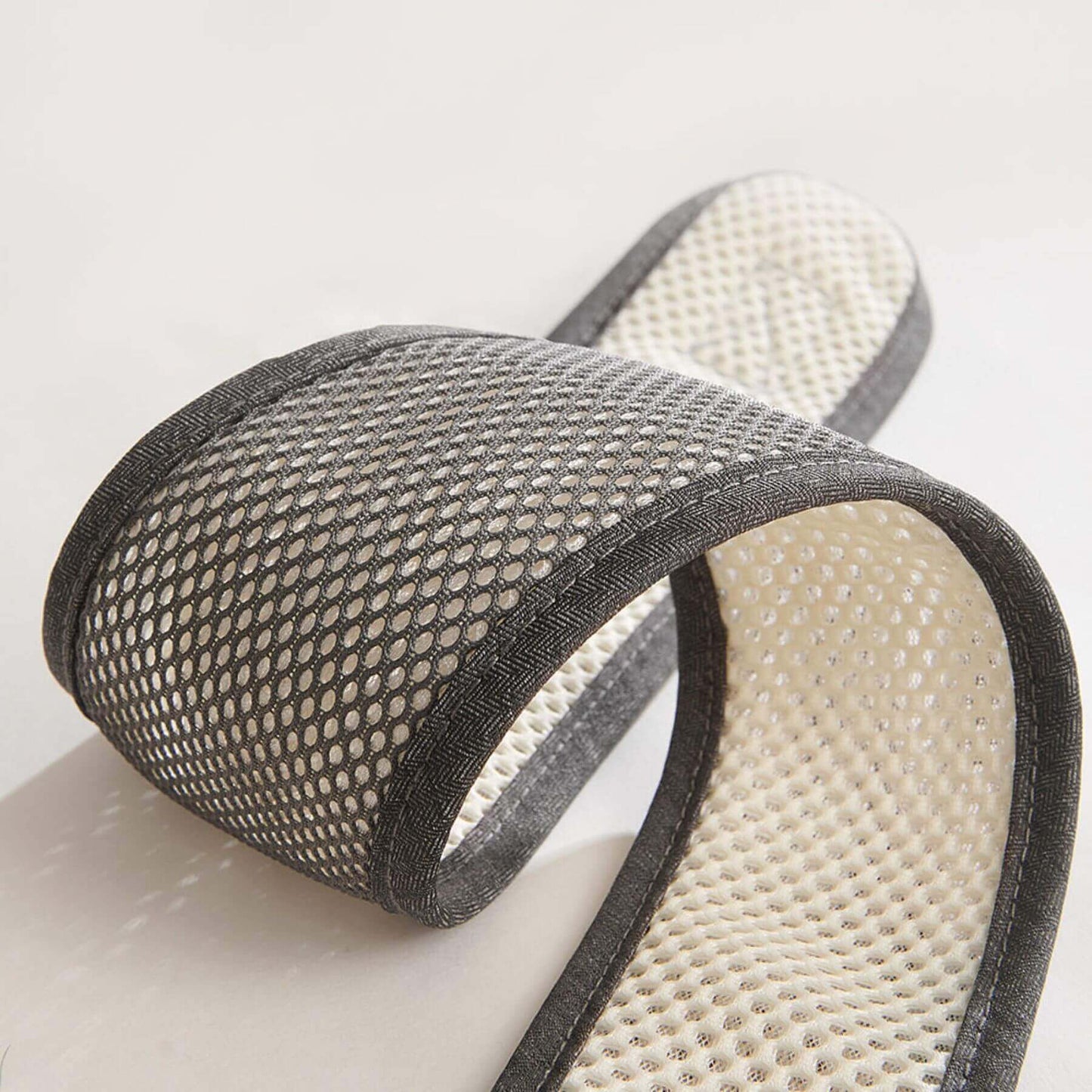 Pair of gray mesh slippers on a light background