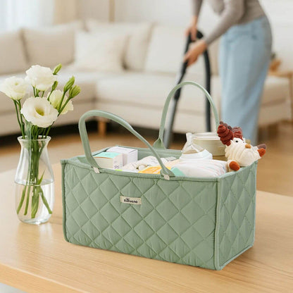 Sunveno Quilted Diaper Caddy Organizer - Green on a table with flowers and cleaning supplies in the background