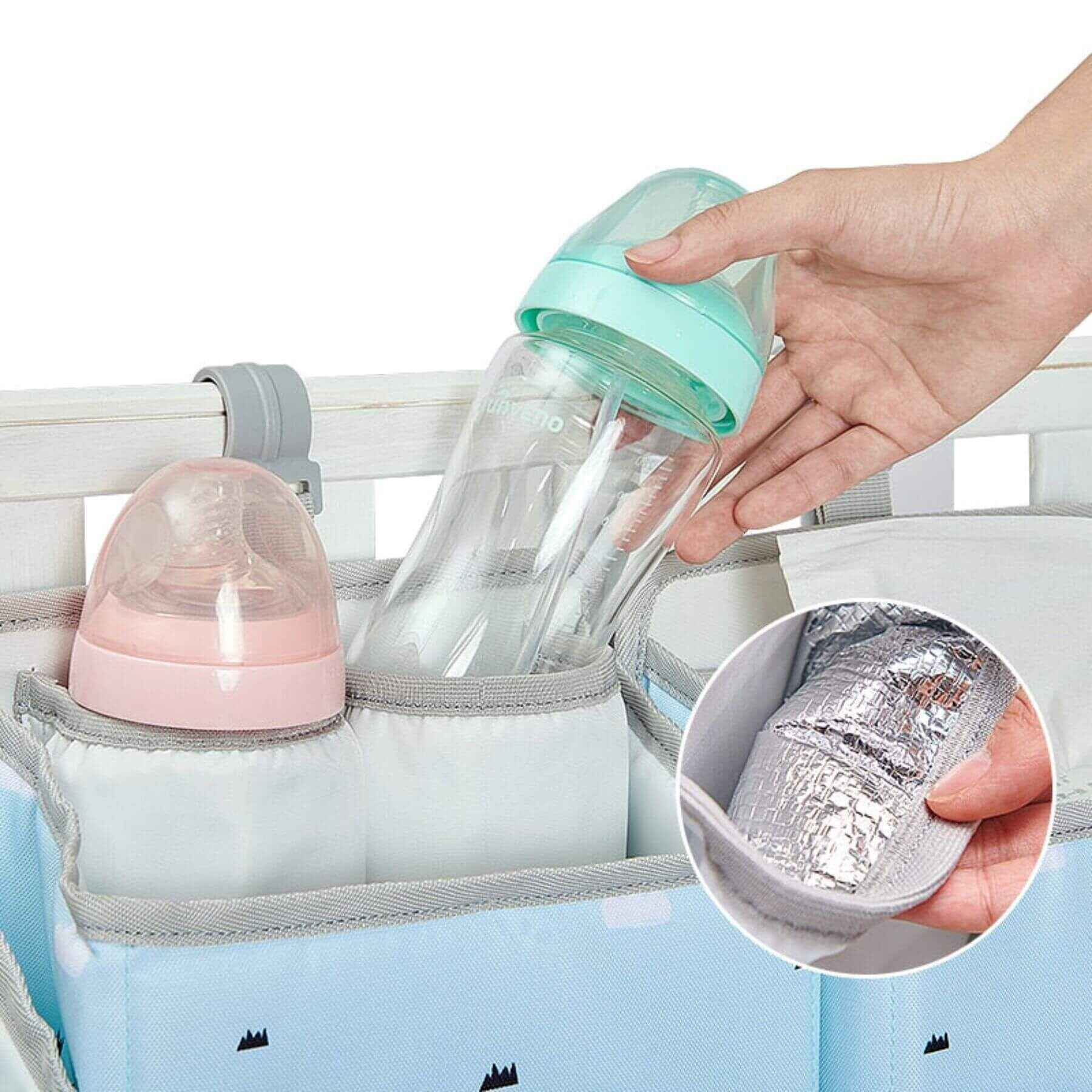 Baby bottle in Sunveno 3-in-1 Crib Organizer with a hand holding the bottle, showing the insulation feature.