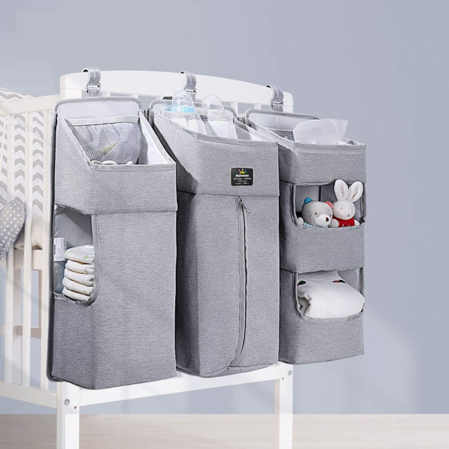 Crib with Sunveno 3-in-1 Crib Organizer Gray containing baby items on a light gray background
