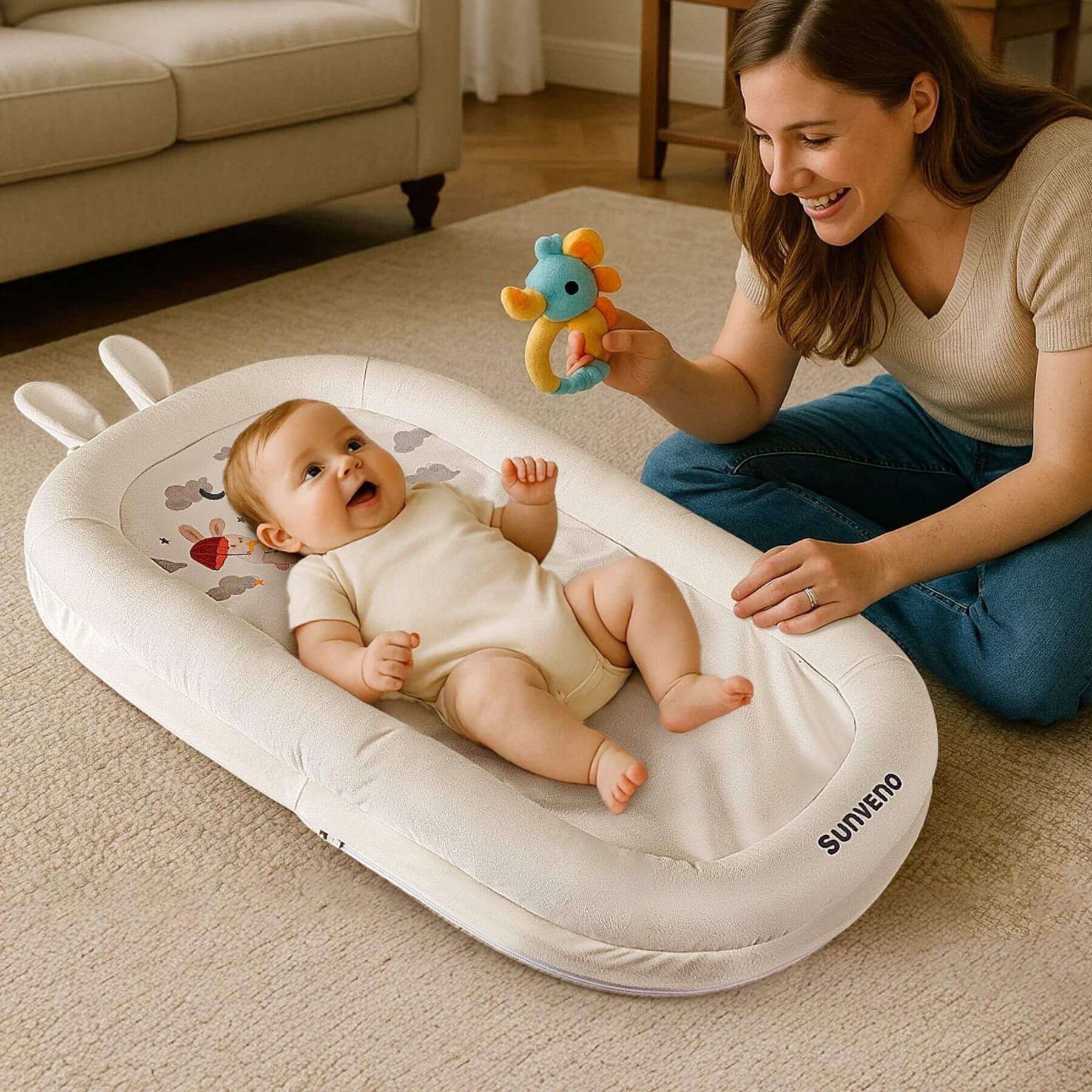 Mom plays a toy with baby, sleeping on Sunveno Baby Lounger for Newborns - White
